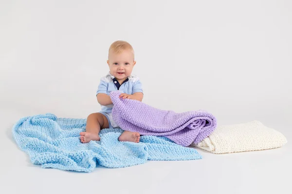 Kid with plush colored blankets on the white background