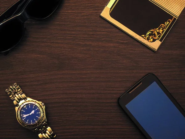 Adam aksesuar ile becerikli alet, güneş gözlüğü, saati, kartları ve diğer lüks özellikleri ahşap arka plan üzerinde iş tarzında. Casual, ofis ya da moda stil. Boş boş yer, mockup metin mesajı veya medya içeriği için
