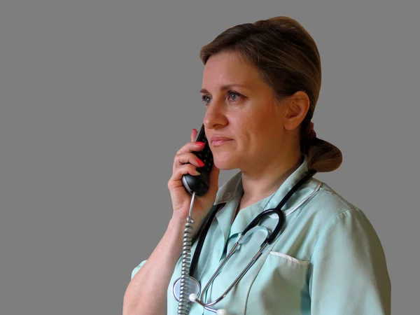 Chiamata di dottore o infermiera per telefono. Donna in uniforme con portatile — Foto Stock