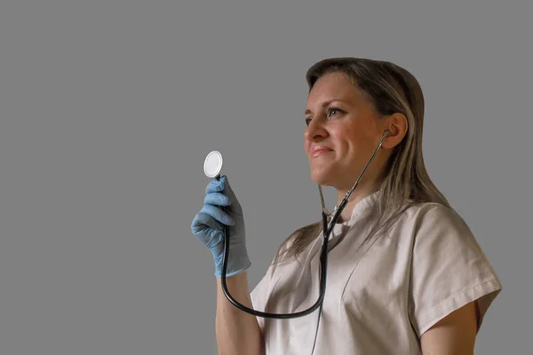 Femmina medico o infermiere tiene in mano lo stetoscopio e ascoltare pati — Foto Stock