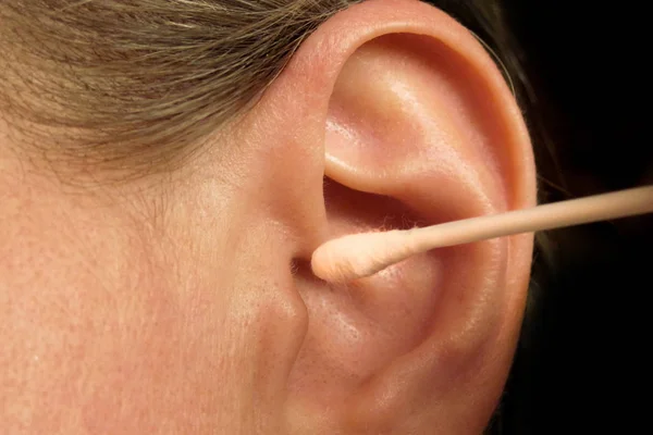 Kobieta w średnim wieku czyszczenia ucha wacikiem lub kij. Cl — Zdjęcie stockowe