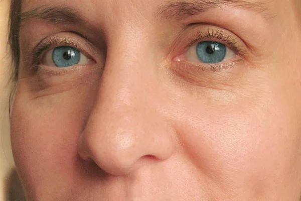 Closeup of middle aged woman face with blue eyes