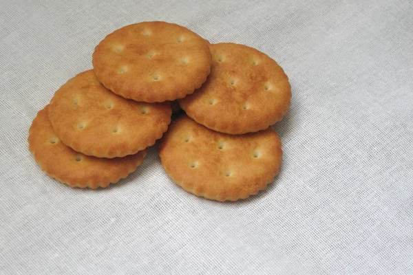 Crackers of bakkerij voedsel gelegd op witte stof tafelkleed — Stockfoto