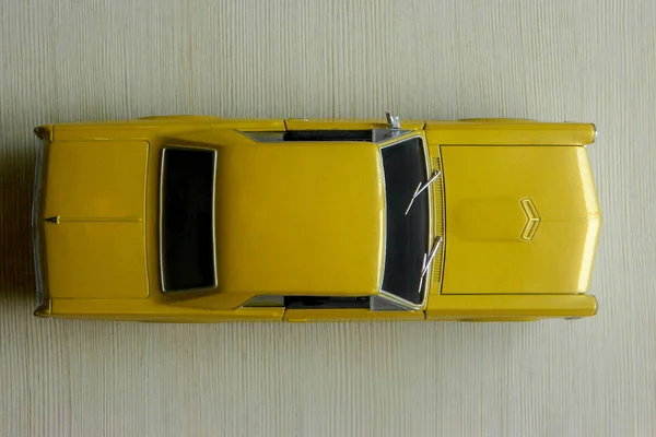 Coche de juguete amarillo en superficie rayada gris. Modelo de músculo clásico — Foto de Stock