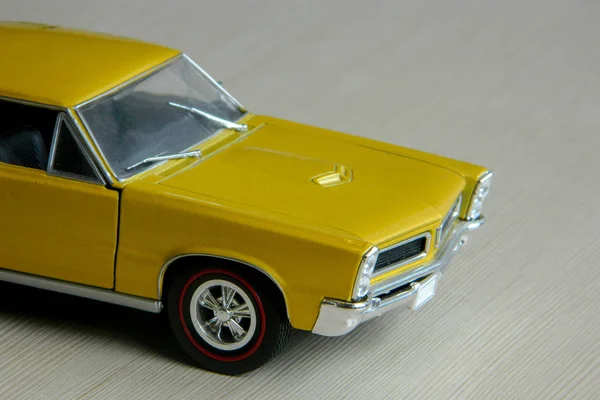 회색 줄무늬 표면에 노란색 장난감 자동차입니다. 클래식 근육의 모델 — 스톡 사진