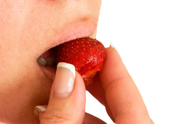 Woman bites and eats strawberry closeup image