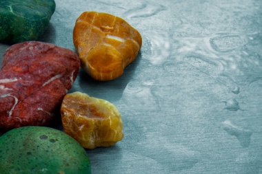 Renkli taşlar su damlaları ile yüzeyde görüntü kapatın. Mineral elementlerin soyut arka planı veya doğal peyzajı