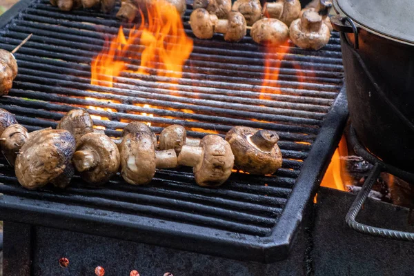 Mushrooms grill. Champignons are fried or baked on open fire. Ba
