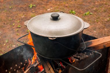 Parti pikniyerinde açık hava mutfağı. Pilav dışarıda ateşte yemek pişiri.