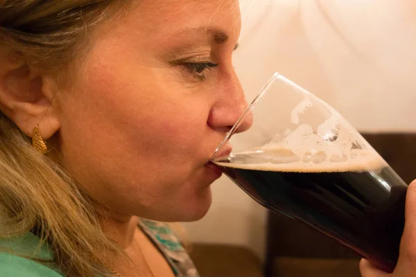Девушка пьет тёмное пиво. Закрыть образ женщины средних лет с — стоковое фото