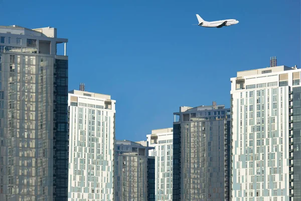 Moderna vista al centro de negocios urbano. Jet avión vuela por encima de un sk — Foto de Stock