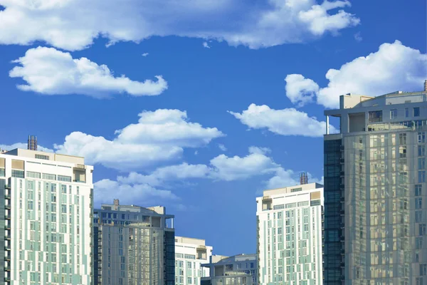 Небоскрёбы или плоские здания на облаках и голубом небе — стоковое фото