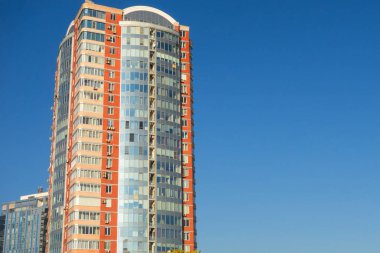 Gökdelen ya da düz blok binası açık mavi gökyüzü arkaplanı. 