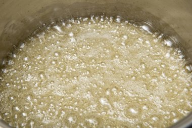 bir tavada ocakta yapılmış olan şeker şurubu