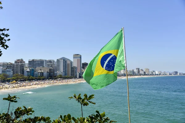Brezilya bayrağı ile arka planda Ipanema Plajı