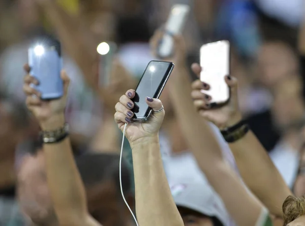 Flaş ile bir cep telefonu tutan kişi ve eller yukarı