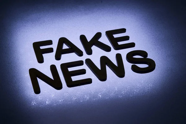 Wort Fake News Holzbuchstaben Geschrieben Und Durch Hintergrund Gegenlicht Beleuchtet — Stockfoto