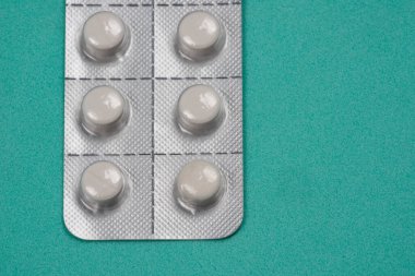 Yeşil arka planda beyaz haplarla izole edilmiş su toplayıcı. Üst Görünüm