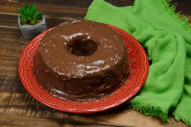 Kırmızı tabakta yuvarlak çikolatalı pasta.