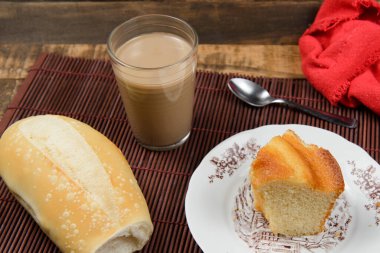 Tipik Brezilya kahvaltısı, bir fincan sütlü kahve ve kek.