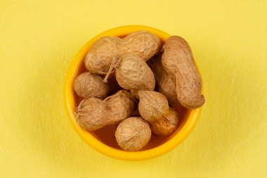 Sarı arka planda kabuklu fıstık yığını.