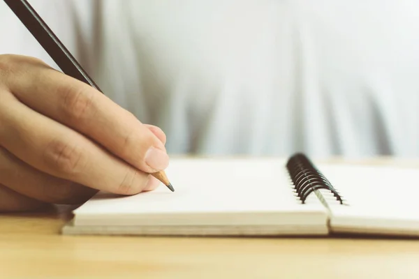 Ręka człowieka z ołówkiem pisanie na notebooku — Zdjęcie stockowe