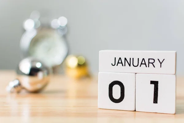 1. Januar, Kalenderholzblock mit Weihnachtskugeldekoration und Uhr auf Tisch, Neujahrsauflösung und Torkonzept — Stockfoto