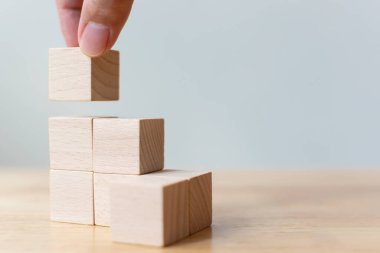 Tahta sehpanın üzerinde merdiven olarak tahta blokları diziyorum. Büyüme süreci için iş konsepti. Boşluğu kopyala