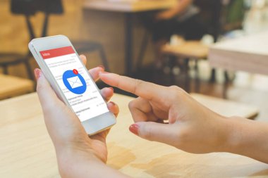 Akıllı telefondan başvuru maillerini kontrol eden bir kadın eli. Akıllı telefondan yeni iletiler bildiriliyor