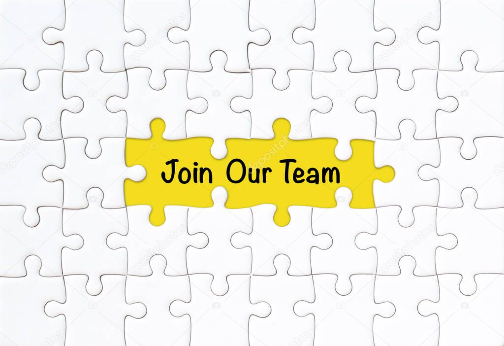Join our team concept. White jigsaw puzzle with word and yellow background