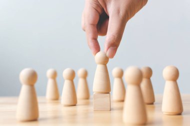 İnsan kaynakları, yetenek yönetimi, işe alım çalışanı başarılı iş dünyası lideri konsepti. El, kalabalığın arasından çıkan tahta insanları seçer..