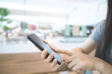 Alışveriş merkezinde cep telefonu kullanan bir kadının resmini kapat.