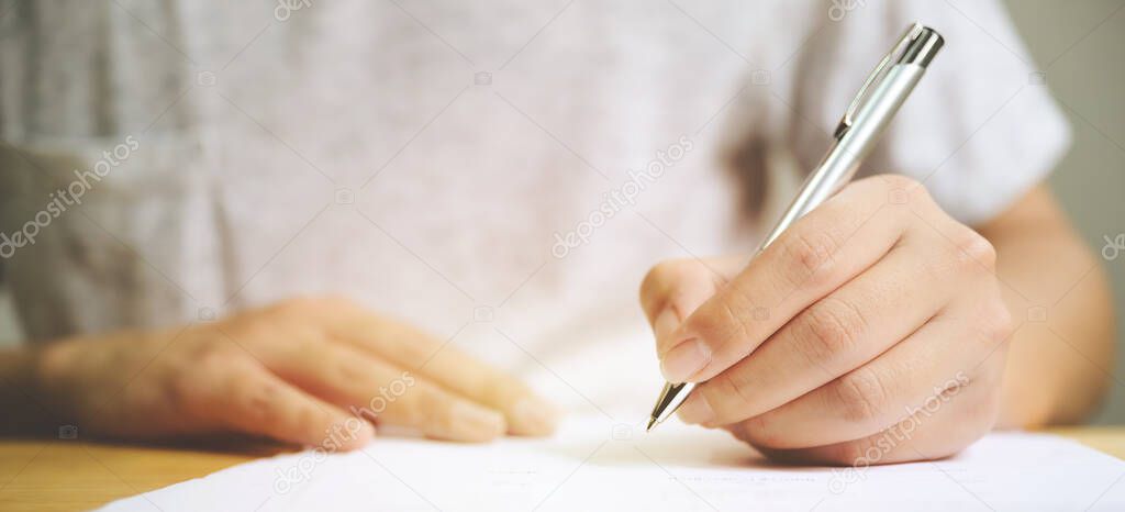 Hand of man signing signature filling in application form document business contract agreement