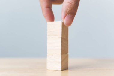 Tahta masa ile ahşap bloğu üst üste dizme el düzenlemesi. Büyüme süreci için iş konsepti