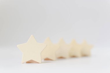 Beyaz arka planda beş yıldızlı ahşap bir şekil. En iyi iş hizmetleri derecelendirme müşteri deneyimi konsepti