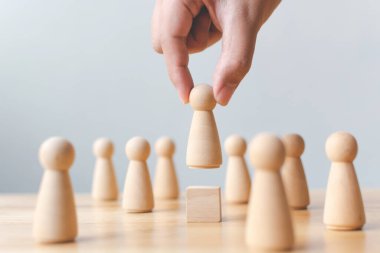 İnsan kaynakları, yetenek yönetimi, işe alım çalışanı başarılı iş dünyası lideri konsepti. El, kalabalığın arasından çıkan tahta insanları seçer..