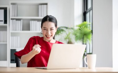 Heyecanlı bir bayanın sevinçle kutlaması çevrimiçi galibiyet başarısı sonucu, iyi e-posta haberlerinden mutlu genç bir kadın, büyük bir teklifle ya da yeni bir fırsatla motive olmuş, sınavı geçmiş, bir iş bulmuş.