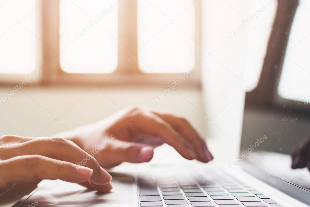 Close-up image of male hands working on laptop searching or typing message for new project
