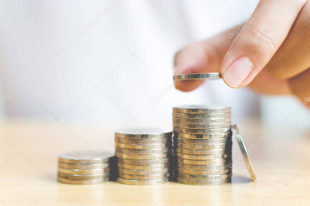 Concept save money financial business investment. Hand of male putting coins stack step growing growth value