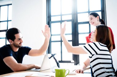 Başarılı girişimciler ve iş adamları hedeflerine ulaşıyor. Mutlu şirket takımı gülüşleri ve tezahüratları için beşlik çakıyor. Görüntü hareket bulanık tekniği.