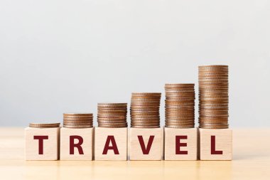 Para sikkeleri basamakları büyüyen basamaklar ve kelime yolculuğuyla birlikte tahta küp blokları istifliyor. Yatırım ve tasarruf kavramı