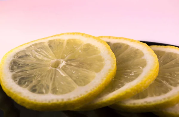 Rodajas de limón en un plato negro — Foto de Stock