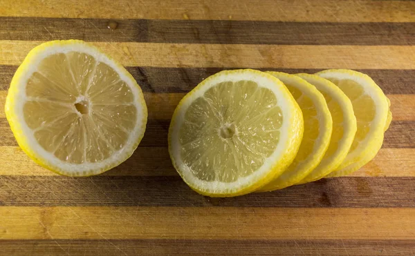 Rodajas de limón en una tabla de madera de cocina — Foto de Stock