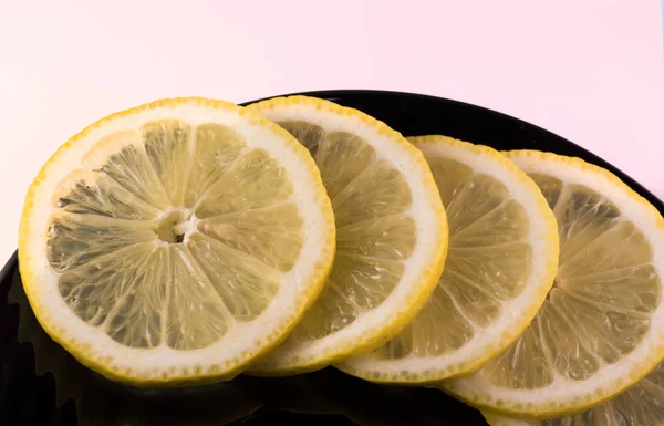 Lemon slices on a black plate, closseup — Stock Photo, Image