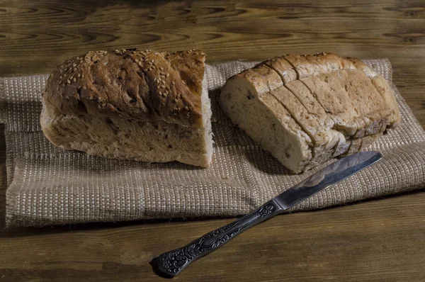 Fresh sliced bread and knife on wooden table. Baking composition — Stock Photo, Image