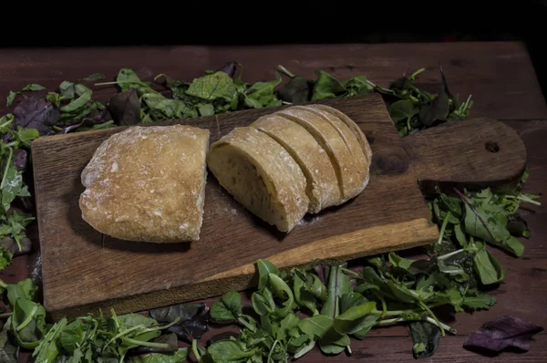 Sliced ciabatta bread on a kitchen board — Stock Photo, Image