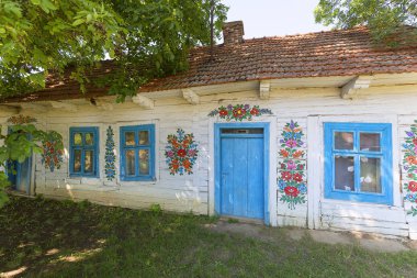 Zalipie, Polonya - 3 Ağustos 2018: Boyalı eski ahşap yazlık bir el boyalı renkli çiçek motifleri, halk ile dekore edilmiş