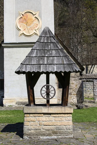14th century Red Monastery, bell tower with sundial, wooden well, Slovakia — Stock Photo, Image