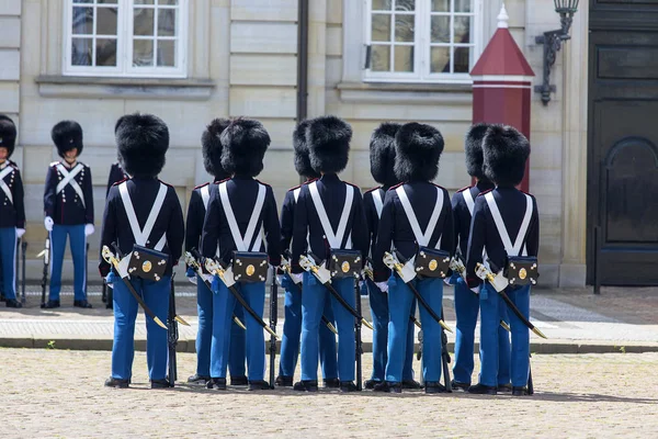 Changing of the guard in the courtyard in front of the Amalienborg palace, guards in historical uniforms and bears fur hats, Copenhagen, Denmark — Stock Photo, Image