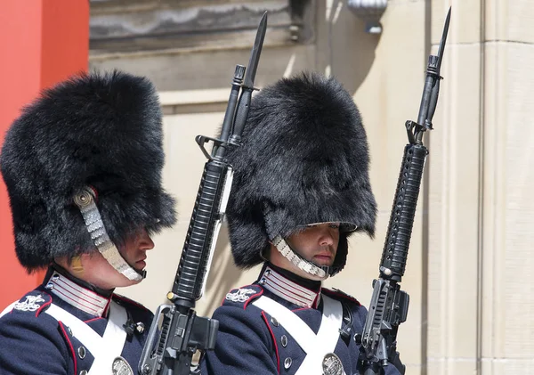 Két őrszem történelmi egyenruhában és szőrmekalapban az Amalienborg palota előtt, Koppenhágában, Dániában. — Stock Fotó